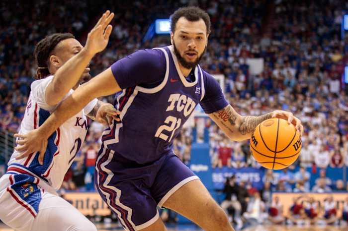 TCU Horned Frogs forward JaKobe Coles (21) drives around Kansas Jayhawks guard Bobby Pettiford Jr. (0) during the first half at Allen Fieldhouse.